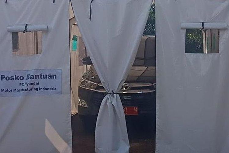 Mobil berpelat merah diparkir di tenda bantuan untuk korban bencana alam Cianjur. 