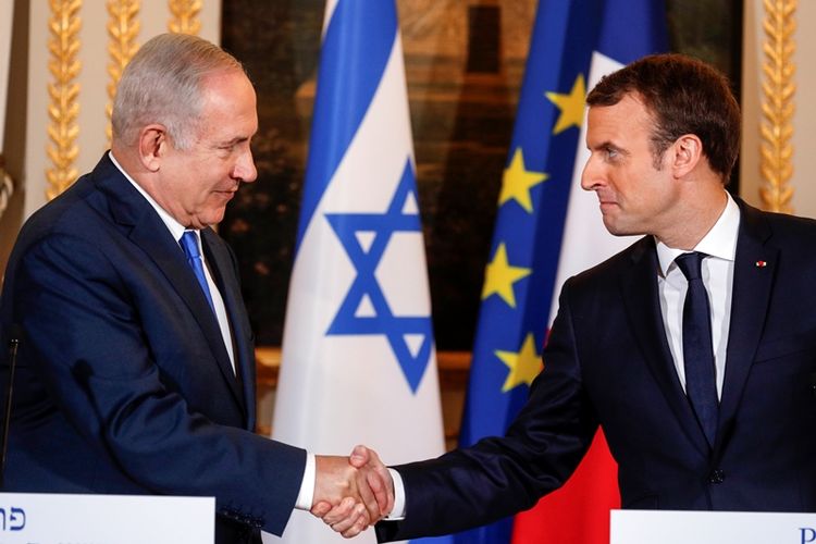 Perdana Menteri Israel Benjamin Netanyahu dan Presiden Prancis Emmanuel Macron berjabat tangan saat jumpa pers bersama setelah pertemuan mereka di Istana Elysee di Paris, Perancis, Minggu (10/11/2017). (AFP/Philippe Wojazer)