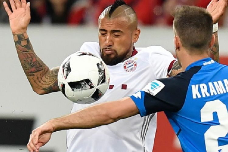 Arturo Vidal (Bayern) berebut bola dengan Andrej Kramaric (TSG 1899 Hoffenheim) pada pertandingan Bundesliga 1 di Rhein-Neckar Arena, Selasa (4/4/2017). 