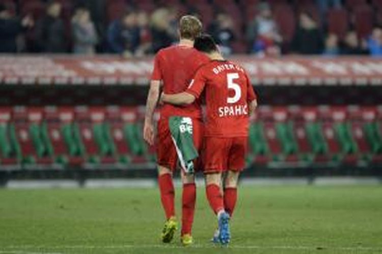 Striker Bayer Leverkusen, Stefan Kiessling (kiri) dan rekan setimnya, Emir Spahic, meninggalkan lapangan usai pertandingan Bundesliga melawan FC Augsburg, Kamis (26/3/2014).