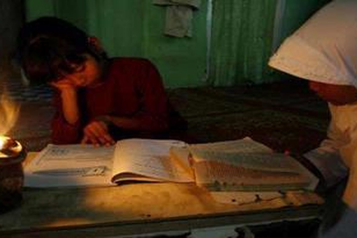 Robiati (10) dan Siti (8), dua siswa Sekolah Dasar ini terpaksa belajar dengan hanya diterangi oleh lampu colok akibat desa mereka yang belum dialiri oleh listrik di Jalan Raja Panjang, kelurahan Tebing Tinggi Okura, kecamatan Rumbai Pesisir Pekanbaru.