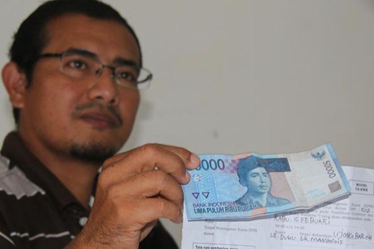 Romi Juliansyah, Ketua Panwaslih Kecamtan Johan Pahlawan, Kabupaten Aceh Barat memperlihatkan  surat undangan pemberitahuan pemungutan suara model C 6 - KWK yang diselipi uang Rp 100.000, Senin (13/02/17)