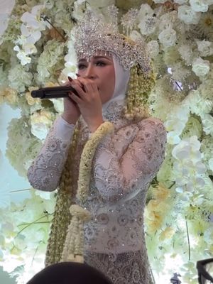 Melly Goeslaw tampil anggun dengan kebaya putih, siger megah, dan ronce melati di perayaan 30 tahun pernikahan, kental nuansa adat Sunda.
