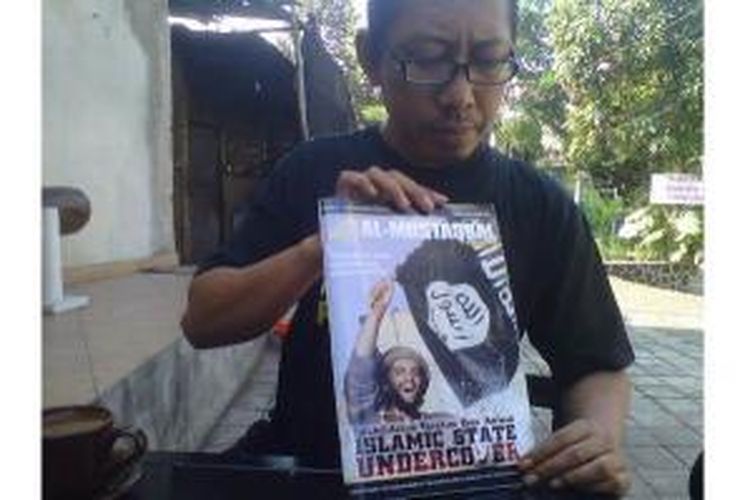 Aji Prasetyo menunjukkan majalah berisi tentang visi dan misi ISIS, yang beredar di Kabupaten Malang, Jawa Timur, Rabu (6/8/2014).