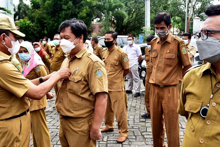 Gubernur Sumut Edy Rahmayadi membetulkan kancing baju seorang ASN saat melakukan sidak ke beberapa kantor OPD untuk memastikan kinerja para aparatur negara di hari pertama kerja pasca libur Lebaran, Senin (17/5/2021)