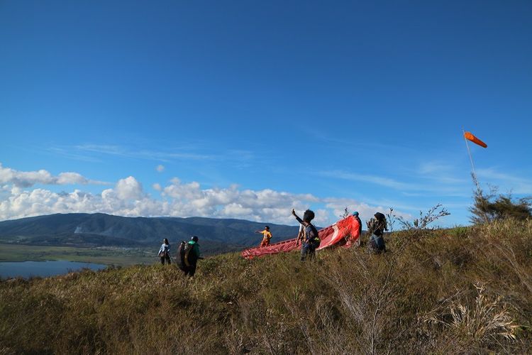 Tim paralayang Mapala UI dalam Ekspedisi Bumi Cenderawasih bersiap untuk terbang melintasi Danau Anggi Giji, Distrik Anggi, Kabupaten Pegunungan Arfak, Papua Barat, Kamis (17/8/2018). Pegunungan Arfak berpotensi dikembangkan menjadi lokasi wisata paralayang.