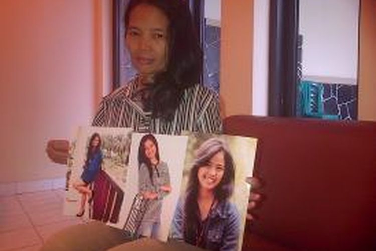 Maria Daria (45) memperlihatkan foto anaknya, Yemima Fanuel Sudarno (18) yang hilang sejak Minggu, 19 Oktober 2014.