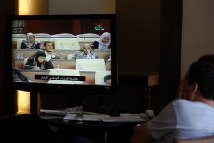 Wartawan di Tripoli, Libya, memantau sidang parlemen Libya lewat televisi, Minggu (4/5/2014). Parlemen melakukan pemungutan suara untuk menentukan dukungan bagi Perdana Menteri sementara Libya, Ahmed Matiq. Pemungutan suara ini diwarnai aksi boikot dari kubu sekuler parlemen tersebut.