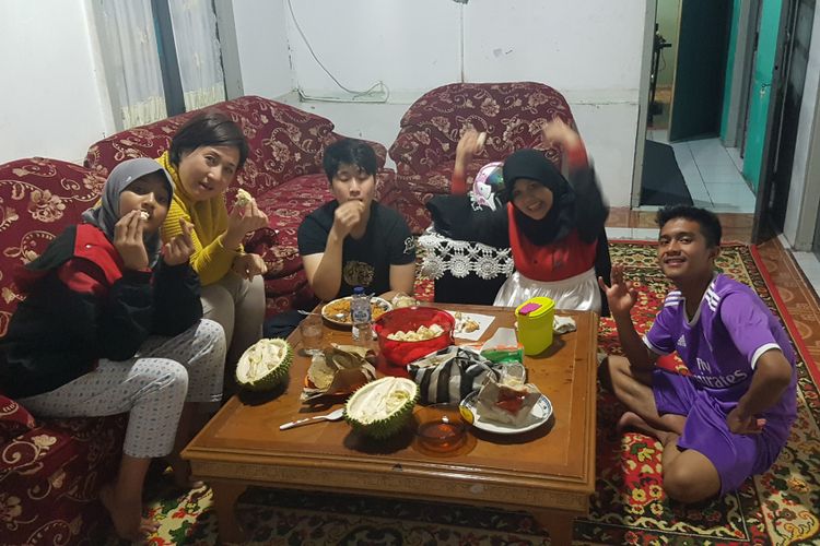 Eje Kim (kedua kiri), profesor asal Korea Selatan yang sangat menyukai durian Indonesia, sedang menyantap bersama anaknya (tengah) dan rekannya di Padang, Sumatera Barat.