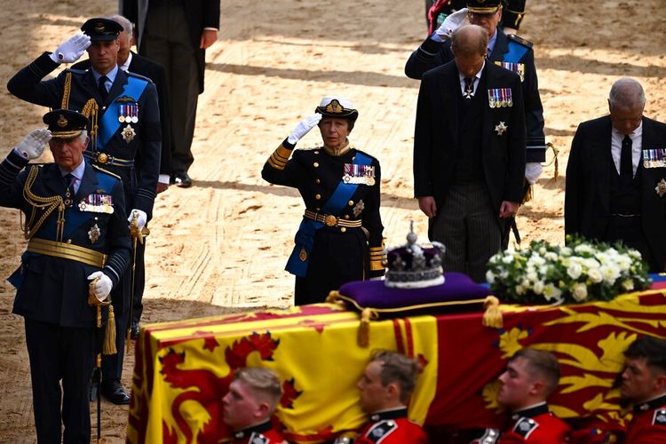 Prosesi pemakaman Ratu Elizabeth II. Raja Inggris Charles III, Pangeran William dari Inggris, Putri Anne dari Inggris, memberi hormat bersama Pangeran Andrew dari Inggris, ketika peti mati Ratu Elizabeth II yang dihiasi simbol Royal Standard dan Mahkota Negara Kerajaan dibawa ke Istana Westminster mengikuti prosesi dari Istana Buckingham, London, Rabu (14/9/2022).