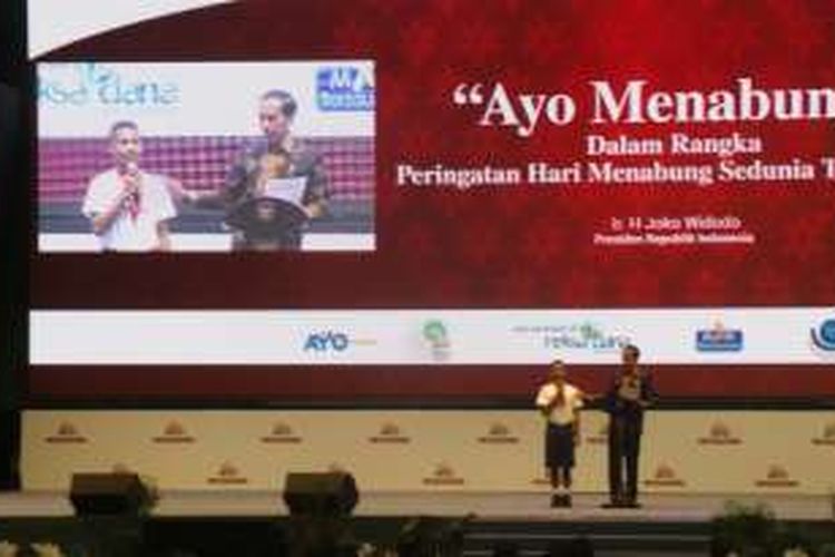 Presiden Joko Widodo bersama salah satu siswa Paulus dj acara Ayo Menabung yang digelar Otoritas Jasa Keuangan, Senin (31/10/2016).