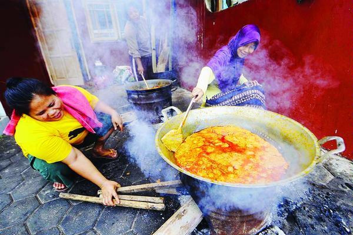 Reno Andam Sari (kanan) memasak rendang daging sapi dengan dibantu dua pekerjanya di rumah produksi Rendang Uni Farah, Cileduk, Tangerang, Banten, Sabtu (24/9). Selain laris di pasar lokal, Rendang Uni Farah juga banyak diminati oleh pembeli dari mancanegara.