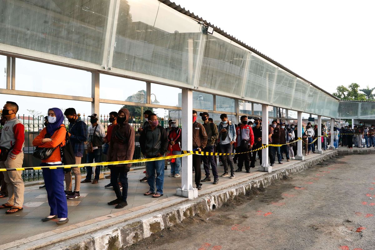 Warga antre menggunakan KRL Commuter Line di Stasiun Bogor, Senin (15/6/2020). Dinas Tenaga Kerja, Transmigrasi, dan Energi (Disnakertransgi) DKI Jakarta mengatur ketentuan waktu masuk, pulang, dan istirahat kantor bagi pekerja atau karyawan di Ibu Kota selama masa transisi pembatasan sosial berskala besar (PSBB).