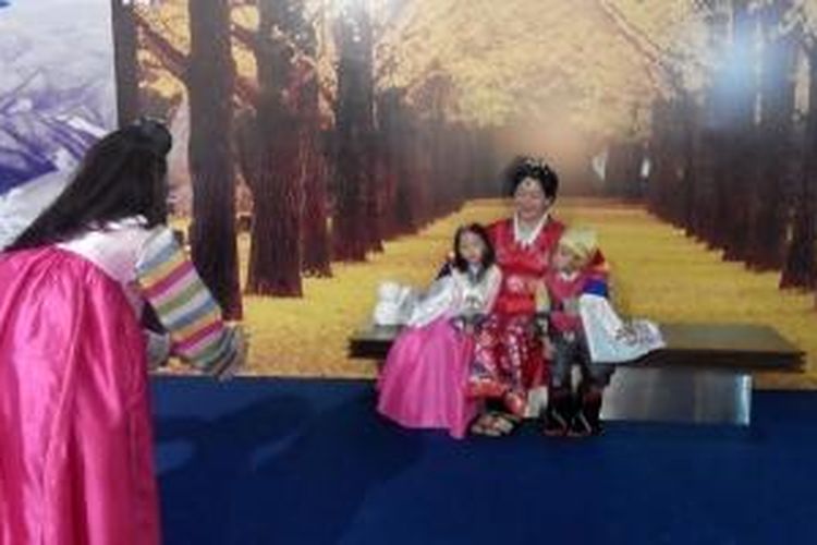 Pengunjung pameran pariwisata Provinsi Gangwon, Korea Selatan, di Jakarta, Jumat (1/5/2015), berfoto dengan busana tradisional Korea, hanbok.
   