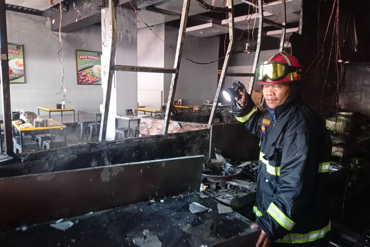 Salah satu petugas pemadam kebakaran Kota Malang sedang melakukan identifikasi terhadap bagian dapur rumah makan Waroeng Steak and Shake yang terbakar di Jalan Ciliwung, Kelurahan Purwantoro, Kecamatan Blimbing, Kota Malang pada Kamis (3/2/2022) siang