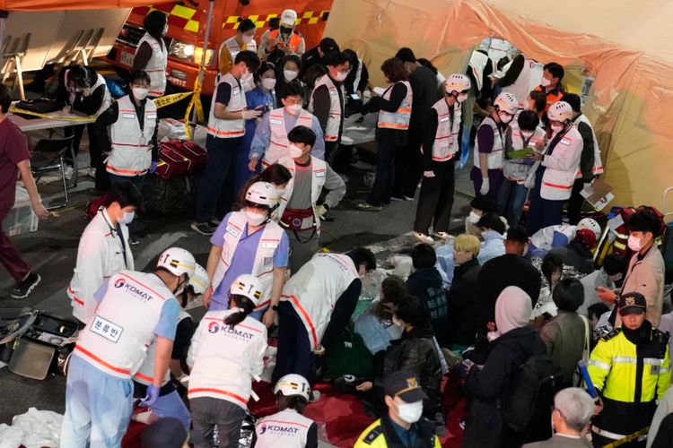 Petugas penyelamat merawat orang yang terluka di jalan dekat lokasi kejadian di Seoul, Korea Selatan, 30 Oktober 2022.