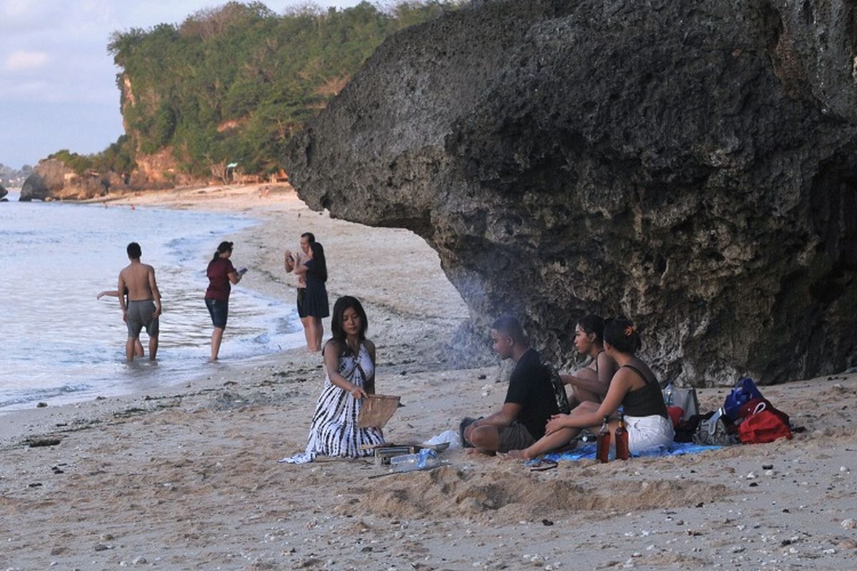 Sejumlah wisatawan mengunjungi kawasan Pantai Thomas, Padang-Padang, Badung, Bali, Minggu (1/11/2020). Berbagai objek wisata di Pulau Dewata ramai dikunjungi oleh wisatawan domestik dari berbagai daerah yang berwisata memanfaatkan hari terakhir masa libur panjang. ANTARA FOTO/Fikri Yusuf/aww.