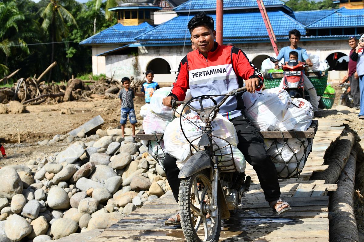 Salah seorang pekerja Pertamina mendistribusikan BBM di daerah yang susah terjangkau.