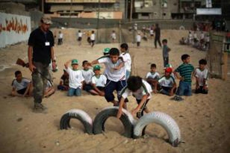 Anak laki-laki Palestina ambil bagian dalam latihan perang selama liburan musim panas yang diselenggarakan oleh Hamas di Kota Gaza, 10 Juni 2013.