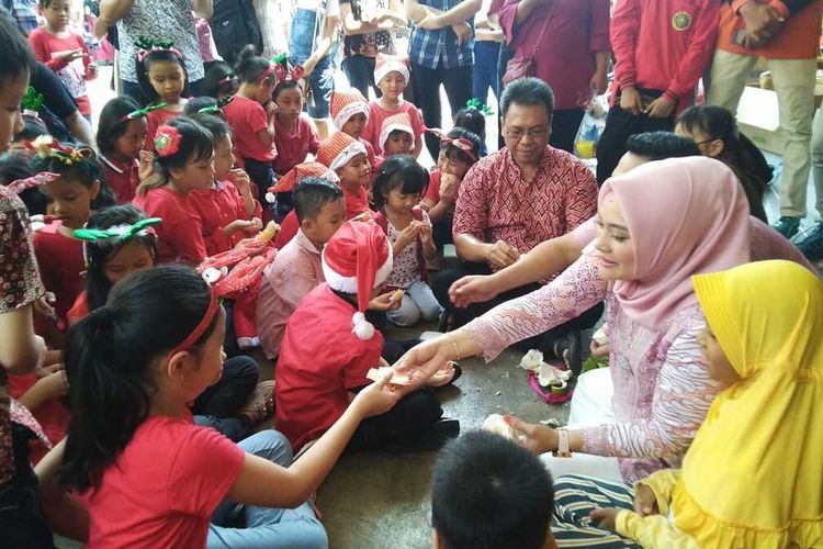 

Wakil Walikota Madiun, Inda Raya bersama pemuda-pemudi muslim membagikan donat dan jeruk bagi anak-anak yang merayakan Natal di Gereja St Cornelius Kota Madiun, Rabu (25/12/2019)