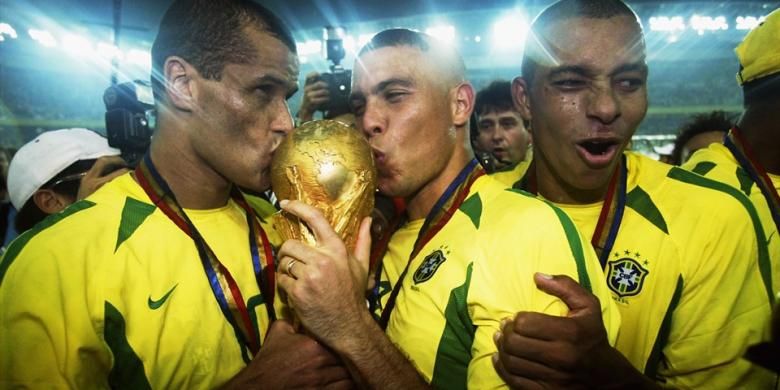 Striker Brasil, Ronaldo (tengah) dan Rivaldo (kiri) mencium trofi Piala Dunia yang mereka raih ketika menjadi juara Piala Dunia 2002 di Korsel-Jepang. Ini gelar kelima Brasil setelah menang 2-0 atas Jerman di partai final di Yokohama, Jepang.