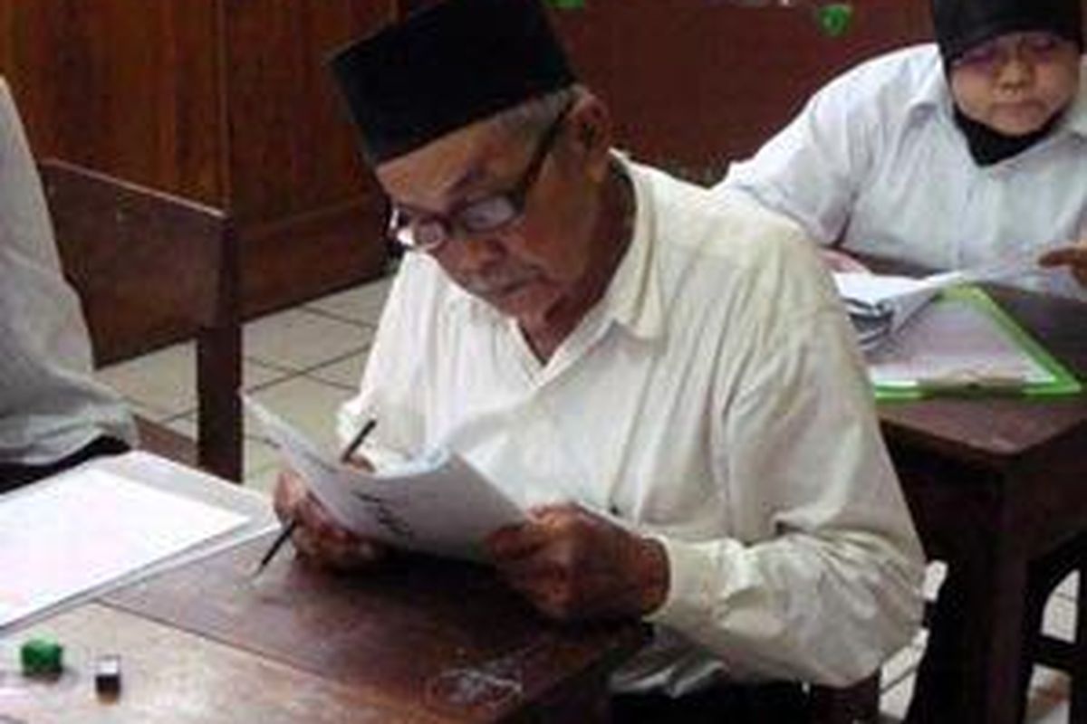 Tarlan (81), kakek 19 cucu, serius mengerjakan ujian Paket A setara SD, Jumat (20/11)