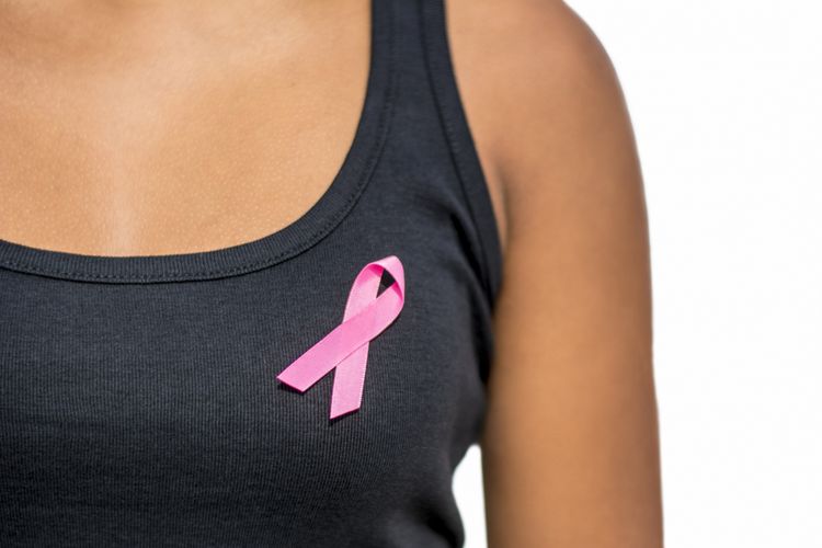 close up of african woman in t-shirt with breast cancer awareness ribbon over white background