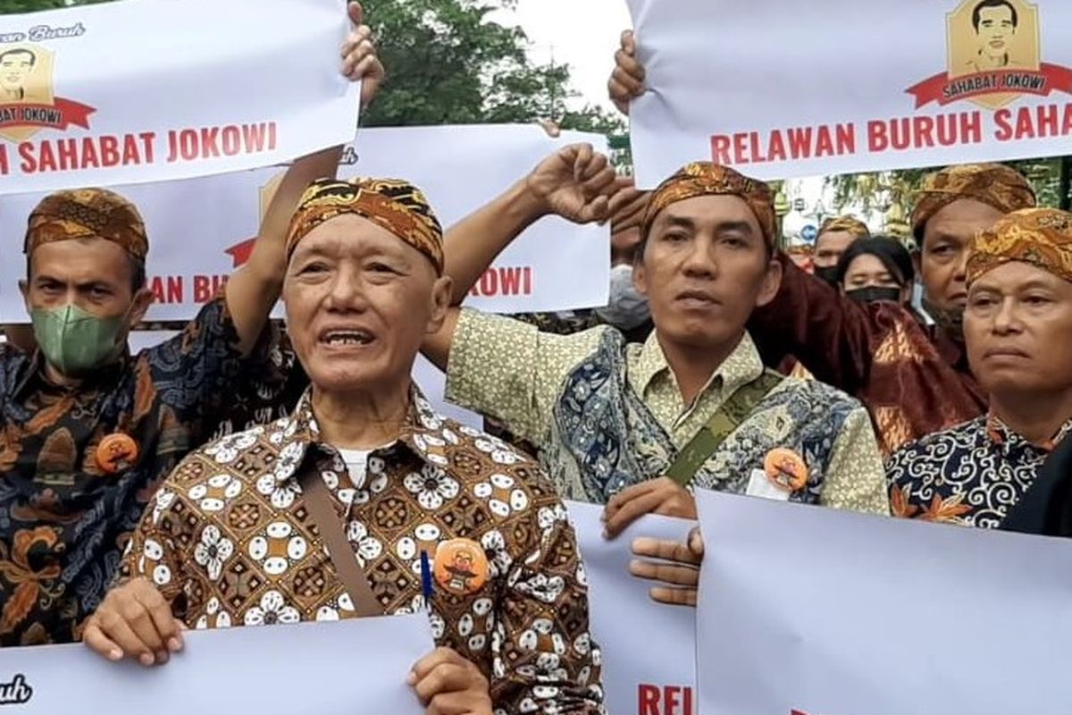 Relawan buruh Sahabat Jokowi menggelar aksi damai membentang poster bersamaan dengan acara ngunduh mantu Presiden Jokowi di Jalan Diponegoro Ngarsopuro tepatnya di depan pintu masuk Pura Mangkunegaran Solo, Jawa Tengah, Minggu (11/12/2022) sore.