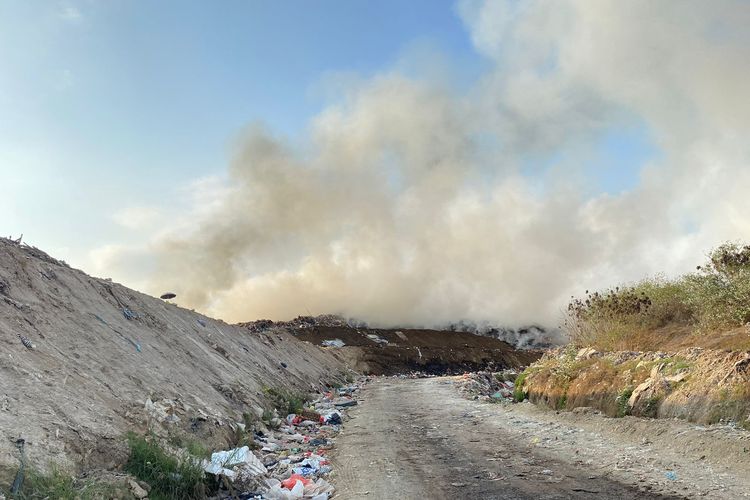 Asap tebal mengepul dari sela-sela tumpukan sampah di Tempat Pembuangan Akhir (TPA) Suwung Kangin, Kelurahan Sesetan, Kecamatan Denpasar Selatan, Kota Denpasar, Bali, pada Jumat (13/10/2023).
