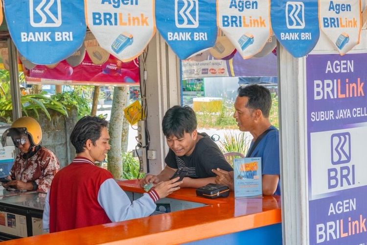 Agen BRILink sedang melayani pelanggan yang hendak melakukan transaksi keuangan. 