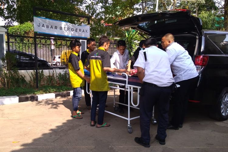 Petugas dari Rumah Singgah Humanis (Rangganis) sedang membantu pasien keluar dari mobil setelah check-up dari rumah sakit Hasan Sadikin.