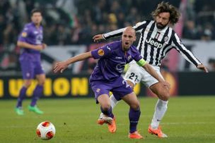 Gelandang Juventus, Andrea Pirlo saat berebut bola dengan pemain Fiorentina, Borja Valero, pada leg pertama 16 besar Liga Europa di Stadion Juventus, Kamis atau Jumat (14/3/2014) dini hari WIB. 