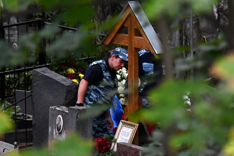 Polisi berdiri di dekat makam pemimpin kelompok tentara bayaran Wagner, Yevgeny Prigozhin, yang tewas dalam kecelakaan jet pribadi di wilayah Tver pekan lalu. Pemakamannya digelar di Porokhovskoye, Saint Petersburg, Selasa (29/8/2023). 