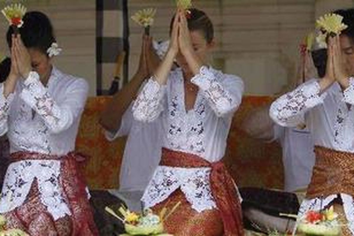 Petenis Slowakia, Daniela Hantuchova (tengah), dan petenis Jepang, Kimiko Date Krumm (kanan), didampingi duta tenis, Angelique Widjaja (kiri), mengikuti prosesi doa bersama menjelang Commonwealth Bank Tournament of Champions di pura Taman Sari, Nusa Dua, Bali, Kamis (4/11/2010). 