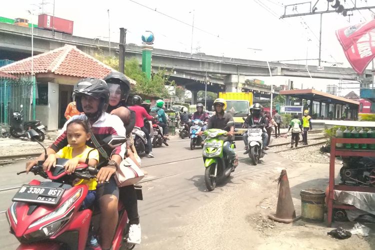 Para pengguna kendaraan bermotor melewati perlintasan KA di Stasiun Ancol. Padatnya jumlah pengguna kendaraan di sekitar Stasiun Ancol membuat petugas harus selalu was-was dan fokus demi menjaga keamanan pengguna jalan dan perlintasan kereta.