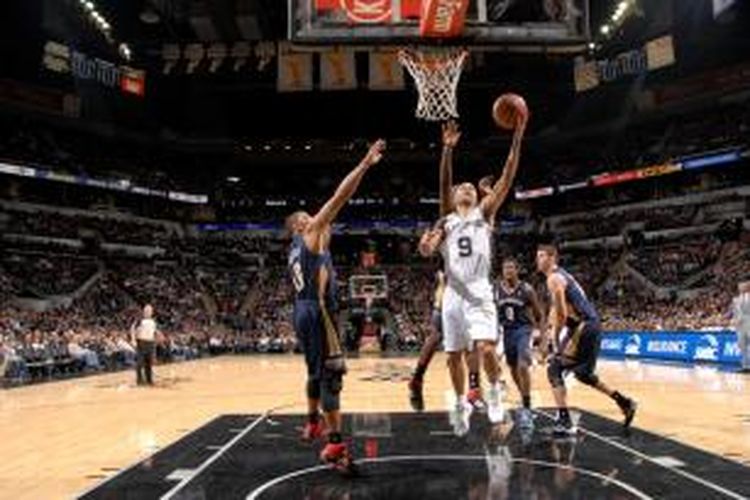 Pebasket San Antonio Spurs, Tony Parker (putih) berusaha memasukkan bola di tengah kerumunan pemain New Orleans Pelicans, saat kedua tim bertemu di AT&T Center, Senin (25/11/2013).