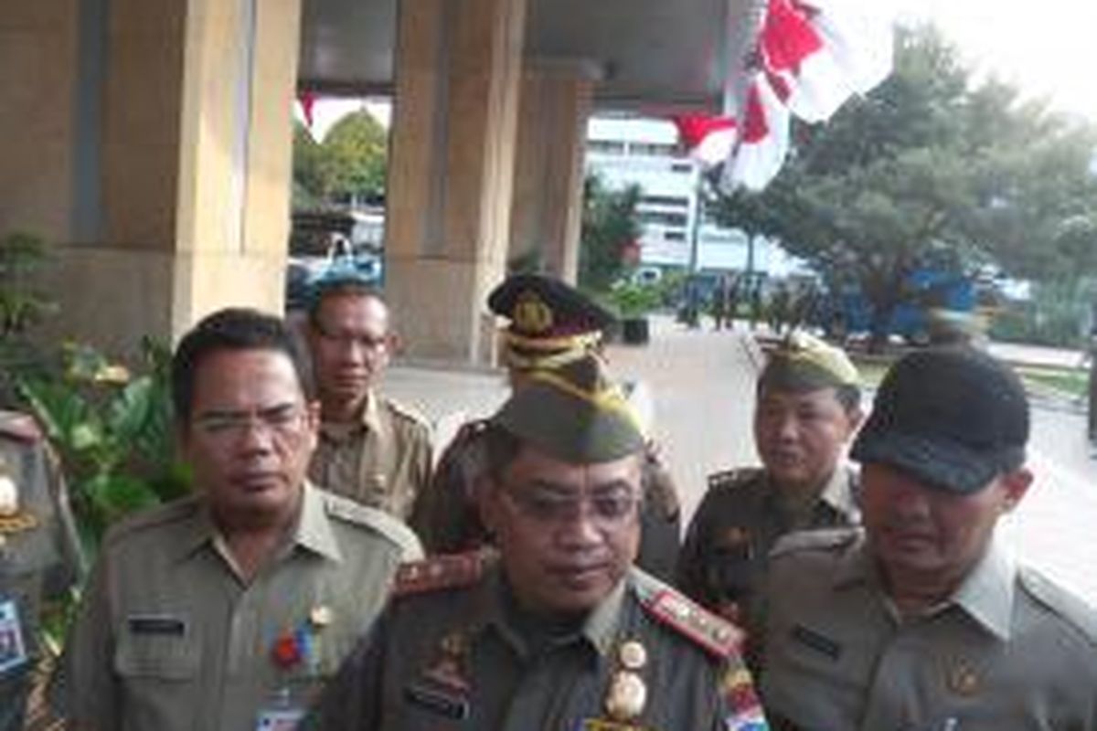 Kepala Satuan Polisi Pamong Praja DKI Jakarta Kukuh Hadi Santoso (tengah) didampingi Kepala Dinas Pariwisata dan Kebudayaan Purba Hutapea (kiri) dan Kepala Badan Kesatuan Bangsa dan Politik Ratiyono (kanan), di Balai Kota, Rabu (17/6/2015)