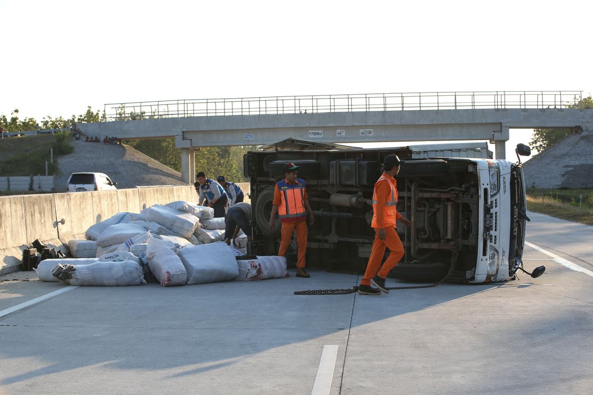 Truk terguling karena mengalami kecelakaan di ruas tol Solo - Ngawi kilometer 555, Ngawi, Jawa Timur, Jumat (24/5/2019). Kecelakaan yang mengakibatkan satu orang luka-luka ini disebabkan pecah ban. 