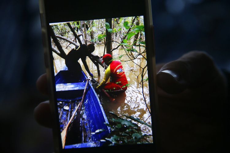 Seorang petugas pemadam kebakaran memegang ponsel dengan gambar yang menunjukkan momen ketika tas ransel ditemukan selama pencarian pakar Pribumi Bruno Pereira dan jurnalis lepas Inggris Dom Phillips di Atalaia do Norte, negara bagian Amazonas, Brasil, Minggu, 12 Juni 2022. 