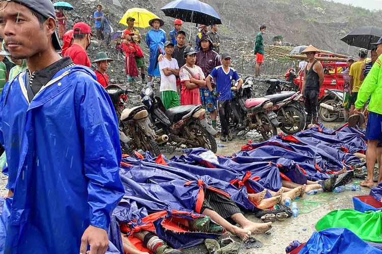 Orang-orang berkumpul di dekat mayat korban tanah longsor di dekat area penambangan batu giok di Hpakant, negara bagian Kachin, Myanmar utara, Kamis, (2/7/2020). Pemerintah Myanmar mengatakan tanah longsor di tambang batu giok telah menewaskan puluhan orang.