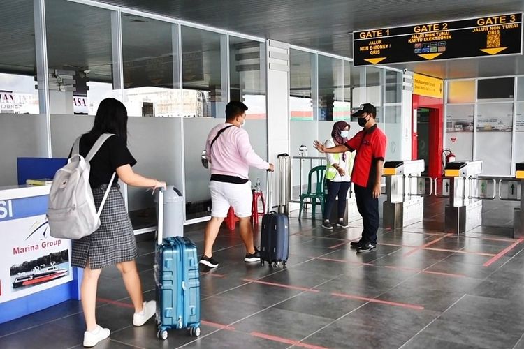 Petugas memantau penerapan Social Distancing pada antrian penumpang yang hendak memasuki gate keberangkatan di salah satu terminal penumpang yang dikelola Pelindo 1, Rabu (23/12/2020)