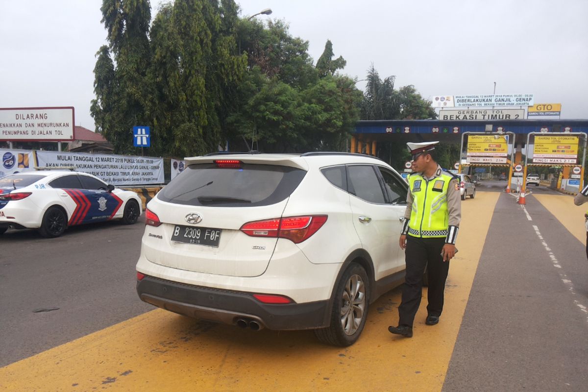 Salah satu mobil berpelat ganjil yang diminta putar balik di depan gerbang tol Bekasi Timur arah Jakarta pada hari pertama penerapan skema ganjil genap Tol Cikampek, Senin (12/3/2018).