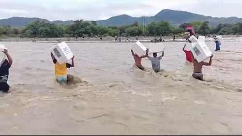 Warga NTT Terobos Banjir Sambil Memikul Puluhan Kotak Suara