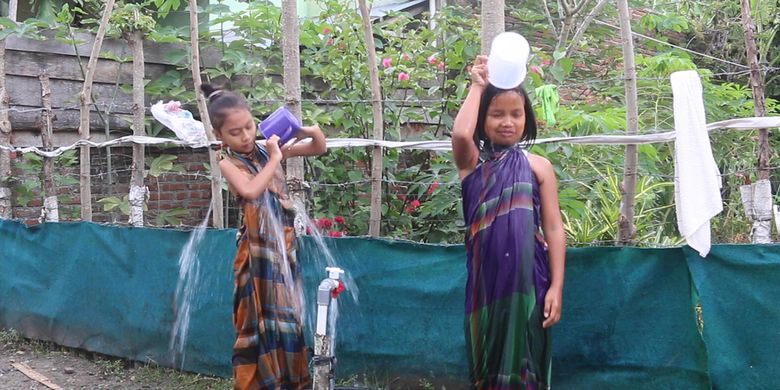 Anak-anak warga Dusun Pelita, Gampong Meunasah Mon, Krueng Raya, Kabupaten Aceh Besar sedang mandi di pekarangan rumah, selama ada bantuan sumur bor dari pertamina mereka tidak perlu lagi harus ke sungai saat mandi. 