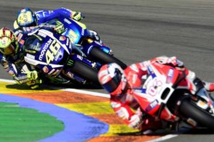 Pebalap Yamaha Movistar Valentino Rossi (paling kiri) melelwati pebalap Team Suzuki Aleix Espargaro saat GP Valencia di Sirkuit Ricardo Tormo, Spanyol, Minggu (8/11/2015).