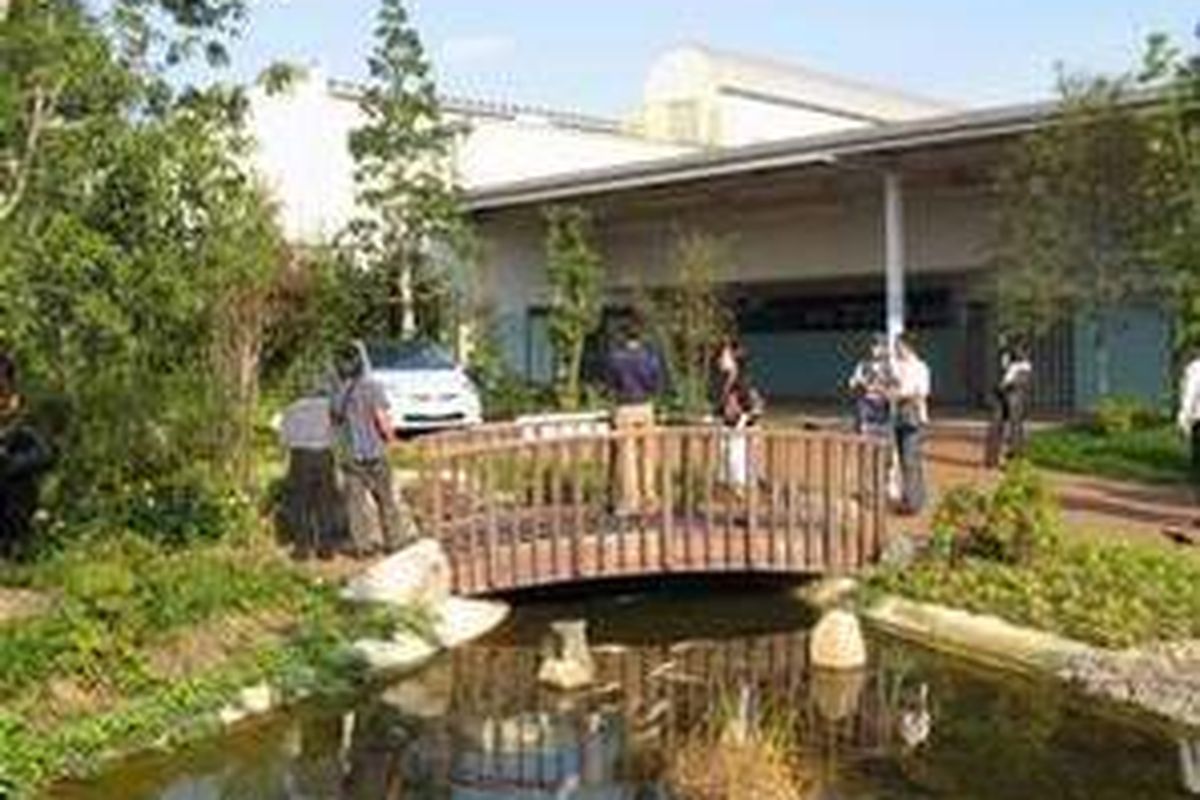 Prius dipajang di halaman yang dipenuhi pohon dan kolam dengan air limbah pabrik yang jernih