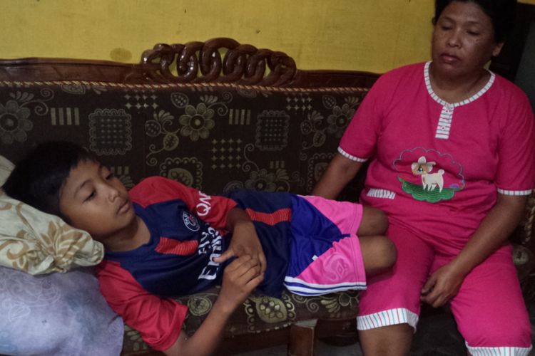 Irfan Ardiansyah, terbaring ditemani neneknya, salah satu siswa SDN Losari 2 Ploso, Kabupaten Jombang, mengalami keracunan setelah mengkonsumsi minuman dalam kemasan plastik pemberian orang asing di sekolahnya, Selasa (6/11/2018).