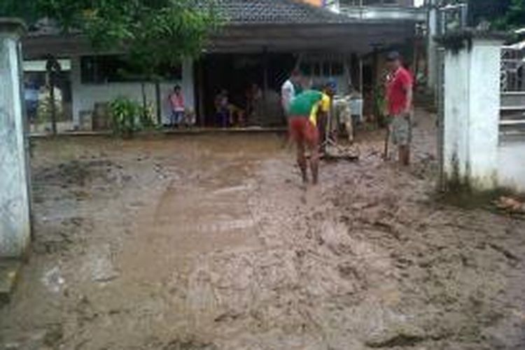 Beberapa warga di Desa Sitiarjo, Kecamatan Sumbermanjing Wetan, Kabupaten Malang, sedang membersihkan halaman rumahnya yang semalam terdampak banjir setinggi satu meter. Rabu (10/7/2013).