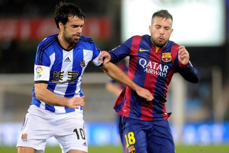 Bek Barcelona, Jordi Alba (kanan) saat berebut bola dengan gelandang Real Sociedad, Xabi Prieto, pada lanjutan Primera Division di Anoeta Stadium, Minggu (4/1/2015). 