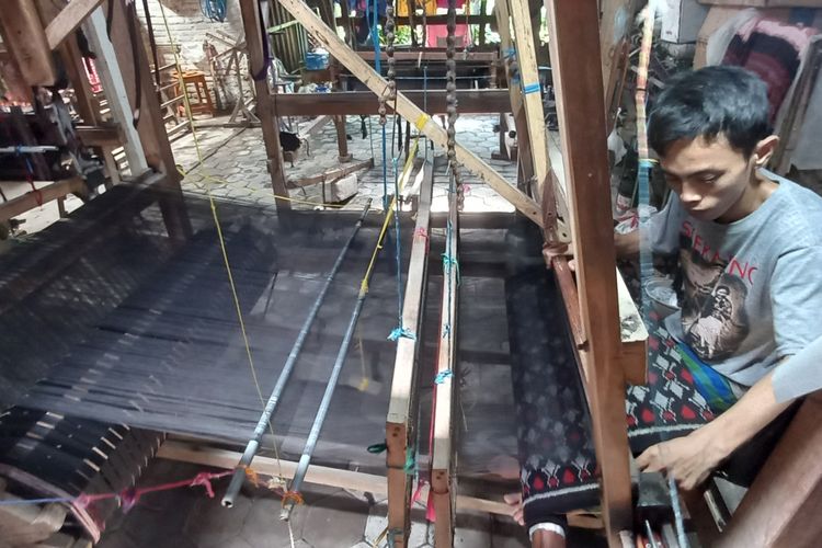 Pekerja tengah membuat kain tenun di sentra kain tenun ikat Bandar Kidul Kota Kediri, Jawa Timur.